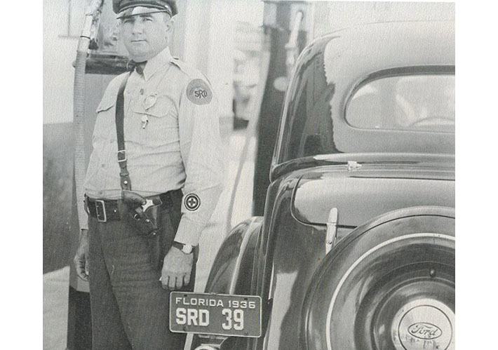 Florida license plate image on car with police officer